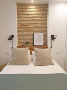 um quarto com uma cama com duas luzes na parede em El Secreto de Portales em Logroño