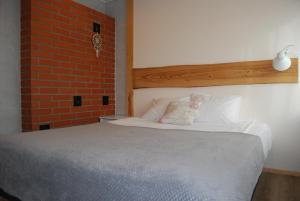 a bedroom with a bed with a brick wall at LiisuPesa Apartment with Sauna and Garden in Pärnu