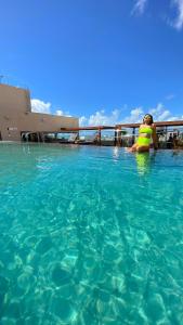 a woman is sitting in a swimming pool at Hotel Manaíra in João Pessoa