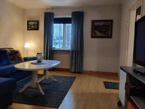 salon ze stołem i kanapą w obiekcie Buskbacken Logi w mieście Bollnäs