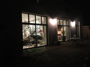 a room with a window at night with a table and a table at L'ATELIER ET APRES in Anet