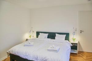 1 dormitorio con 1 cama grande y 2 toallas. en Klimatisierte Wohnung mit großer Terrasse, en Deidesheim