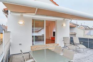 eine Terrasse mit einem Glastisch und Stühlen auf dem Balkon in der Unterkunft Klimatisierte Wohnung mit großer Terrasse in Deidesheim