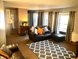 a living room with a leather couch and a rug at Remarkable 2-Bed Apartment in Norfolk Broads in Norwich