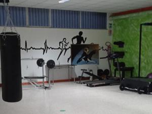 Habitación con gimnasio, TV y pared. en Bunker degli inventori, en Foggia