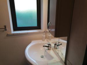 a bathroom sink with a mirror and a window at Villa Africa in Capaci