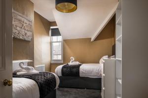 una stanza con due letti e una finestra di The North Shore a Llandudno