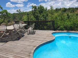 a deck with chairs and a swimming pool at Milkwood Safari Lodge in Warmbaths
