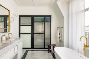 a bathroom with a tub and a sink and a mirror at Kimpton - St Honoré Paris, an IHG Hotel in Paris