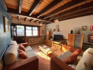 Casa Las Hortensias Quintana في يانس: غرفة معيشة مع أريكة وتلفزيون
