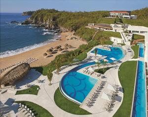 z powietrznego widoku na basen i plażę na terenie ośrodka w obiekcie Secrets Huatulco Resort & Spa w mieście Santa Cruz Huatulco