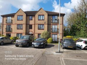 un edificio con coches estacionados en un estacionamiento en Huku Kwetu -The Maltings White Door-1st Floor-2 Bedroom Apartment -Self Catering-Quiet- Free Parking en Dunstable