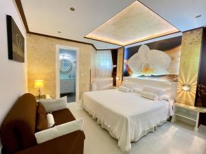 a bedroom with a large white bed and a couch at El Jardin in Soto de la Marina