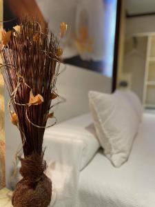 濱海索托的住宿－埃爾加丁酒店，花瓶,在床边的桌子上放着干花