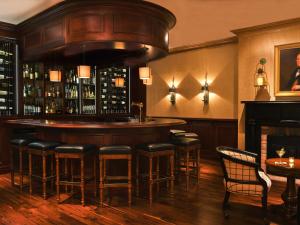 a bar with stools in a room with a fireplace at Inns of Aurora Resort & Spa in Aurora