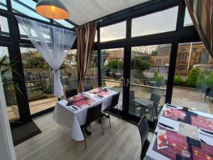 a dining room with a table and some windows at Dukes Folly Hotel in Southport