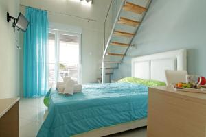 a bedroom with a blue bed and a staircase at Mavridis Rooms 2 in Nikiti