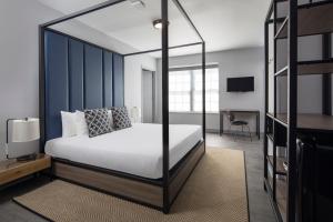 a bedroom with a white bed with a black frame at Hotel Rendale Miami Beach in Miami Beach
