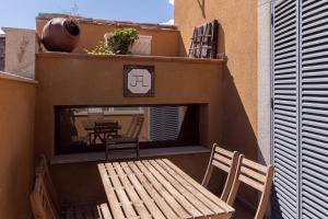 a patio with a wooden table and chairs on a balcony at Casa Chaluca in La Aldehuela