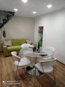 uma sala de estar com uma mesa e um sofá verde em Suite per famiglie"Civico 65" em Palagianello