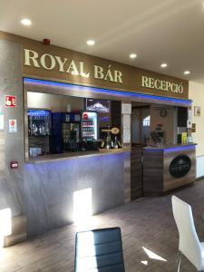 un restaurante con un bar real con barra y sillas en Royal Hotel, en Cserkeszőlő