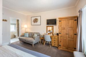 a bedroom with a bed and a chair and a desk at Tudor Lodge in Porthmadog