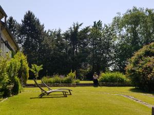 a bench sitting in the grass in a garden at Cozy country house (cottage) & ideal closed garden 