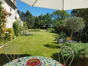 un jardín con mesa y sombrilla en Cozy country house (cottage) & ideal closed garden, 