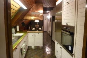 uma cozinha com armários brancos e um frigorífico de aço inoxidável em Ferienwohnung Haus Anne em Büdelsdorf