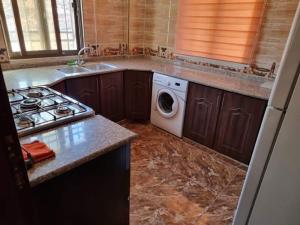 a kitchen with a stove and a washing machine at Green forest farm in Ajloun