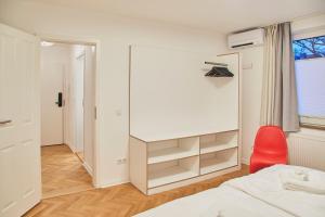 a bedroom with a bed and a red chair at Gemütliche Wohnung mit Balkon in Deidesheim