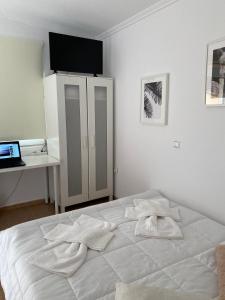 a bedroom with a white bed with a desk and a laptop at Summer Panorama first floor Studio in Epanomi