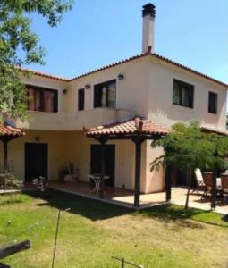 a large white house with a patio in a yard at Gerania Villa in Písia