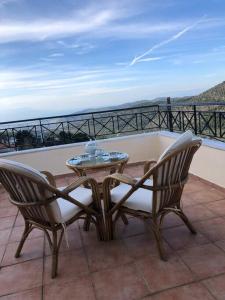 a patio with two chairs and a table on a balcony at Gerania Villa in Písia
