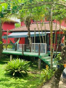 a green bench in front of a red house at Chales Terra Pura in Camburi