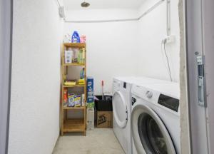 a laundry room with a washing machine and a shelf at Hostel Old School in Rijeka