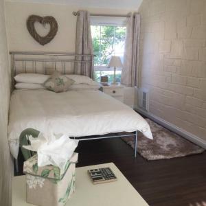 1 dormitorio con 1 cama con un signo cardiaco en la pared en The Hermitage en Great Torrington