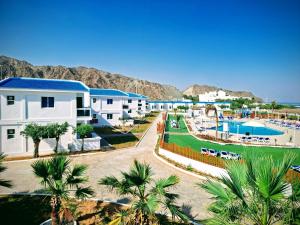 Holiday Beach Resort في دبا: اطلالة على منتجع فيه مسبح والنخيل