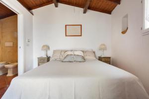 una camera da letto con un grande letto bianco con due comodini di Villa Valeria by BarbarHouse a Torre Vado