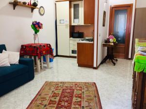 Casa Gamilia في نابولي: غرفة معيشة مع أريكة زرقاء ومطبخ