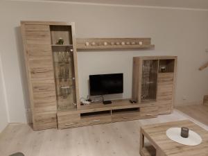 ein Wohnzimmer mit einem großen Unterhaltungszentrum aus Holz in der Unterkunft Ferienwohnung See & Bergblick in Winterberg
