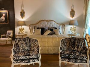 a bedroom with a large bed and two chairs at Antica Dimora Desenzano in Desenzano del Garda