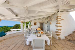 patio ze stołem i krzesłami w obiekcie Villa Valeria by Perle di Puglia w mieście Torre Vado