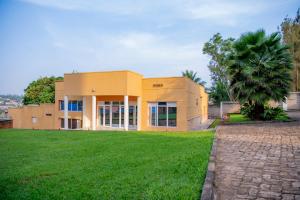 une maison avec une pelouse verte devant elle dans l'établissement Fleur Guest House, à Kigali