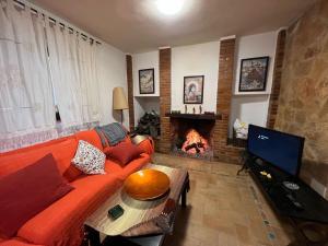 ein Wohnzimmer mit einem Sofa und einem Kamin in der Unterkunft Spanish Townhouse in Spa Village/ Casa rural in Carratraca