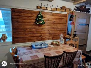 a dining room table with a christmas tree on the wall at Casa Sașilor in Arieşeni