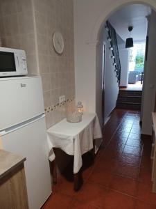 kuchnia ze stołem i białą lodówką w obiekcie La Gonzala w mieście Zahara de la Sierra