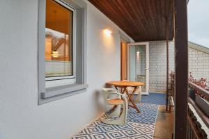 balcón con mesa, sillas y ventana en Gemütliche Wohnung mit Balkon, en Deidesheim