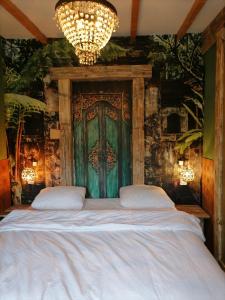 1 dormitorio con 1 cama grande y puerta verde en Villa Le Jardin, en Oude Pekela