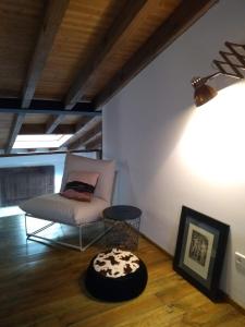een woonkamer met een stoel en een tafel bij La Plazuela del Tiétar, diseño y descanso en Gredos sur in Casavieja
